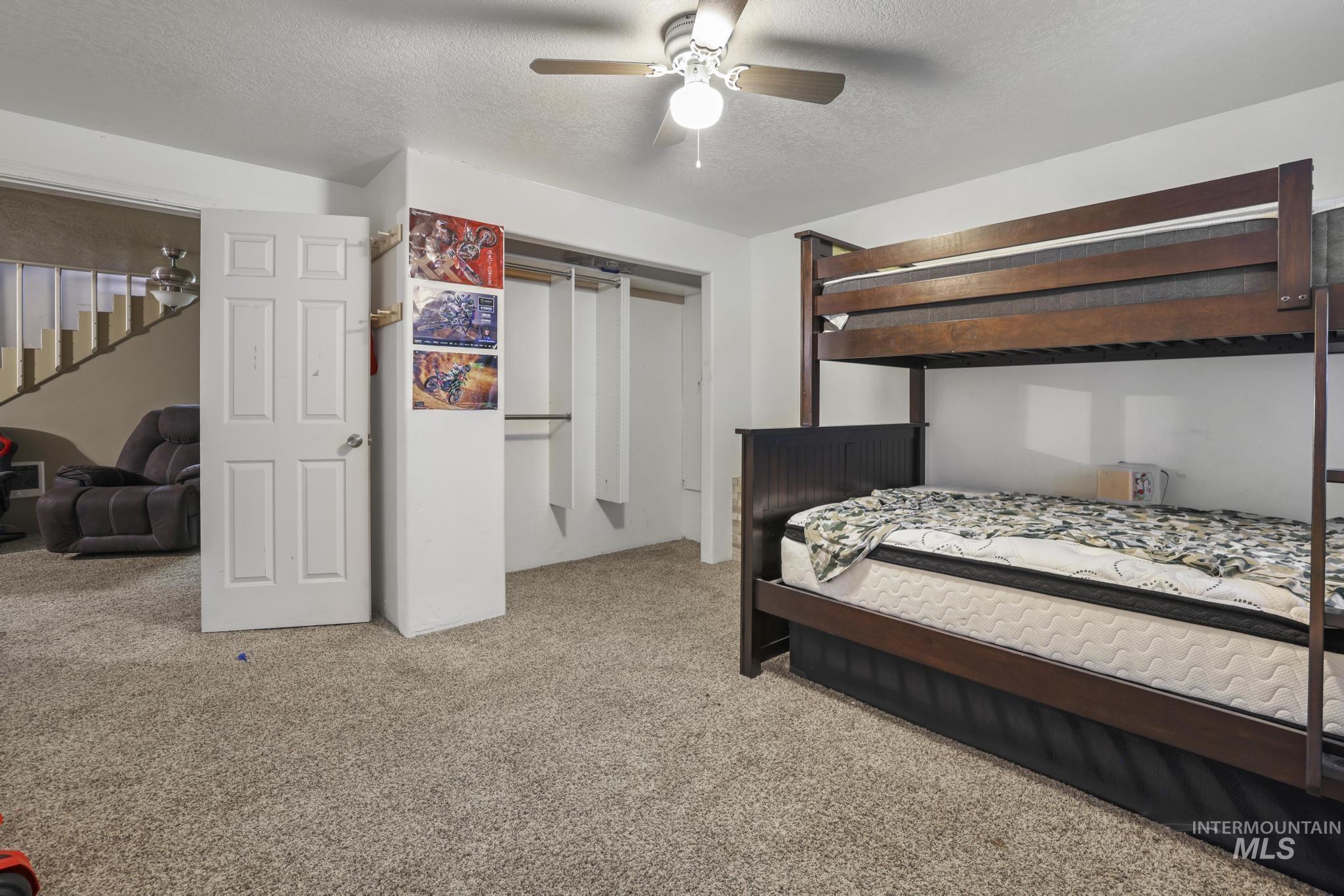 Bedroom featuring carpet, a textured ceiling, a ceiling fan, and a closet