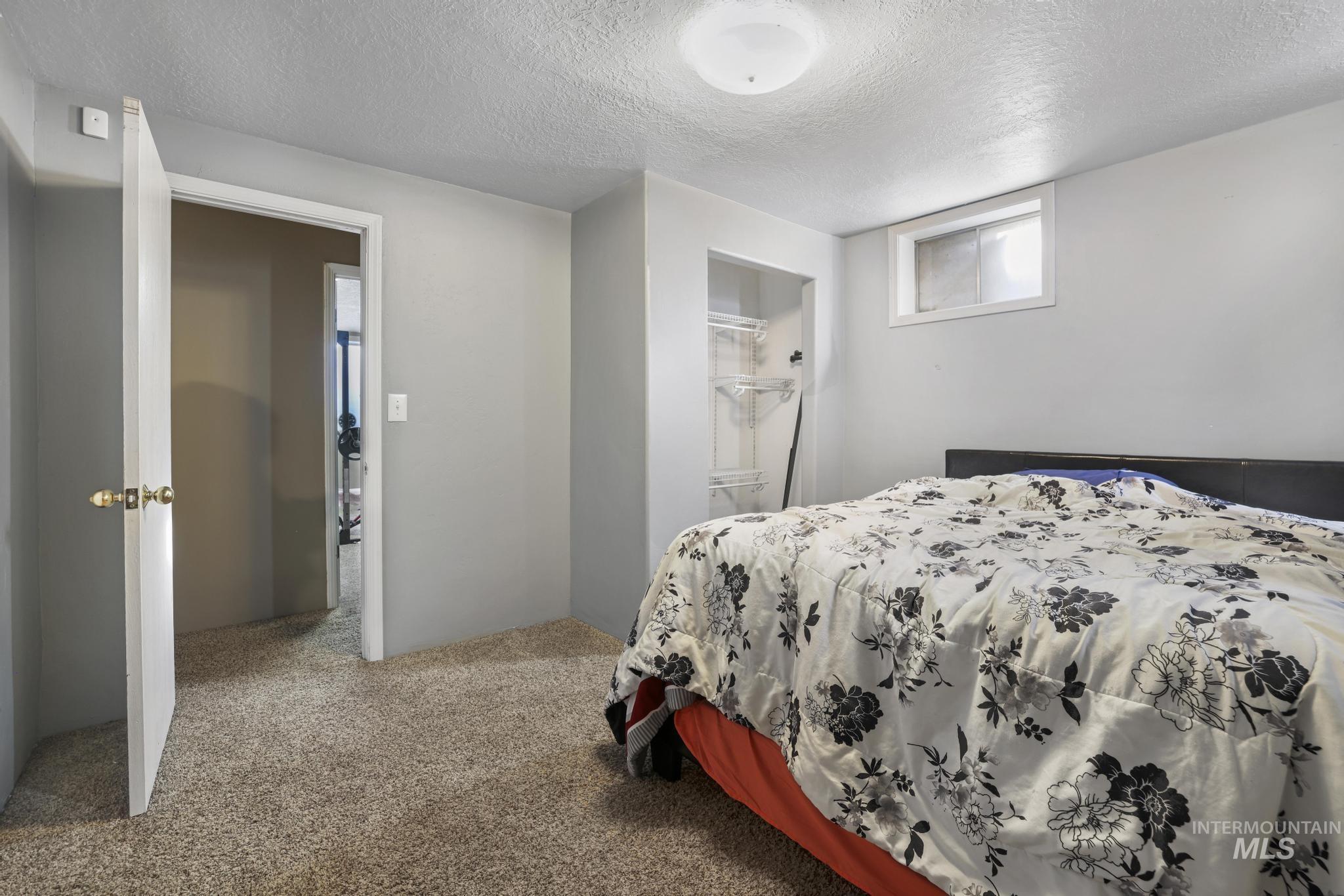 Bedroom featuring a textured ceiling and carpet