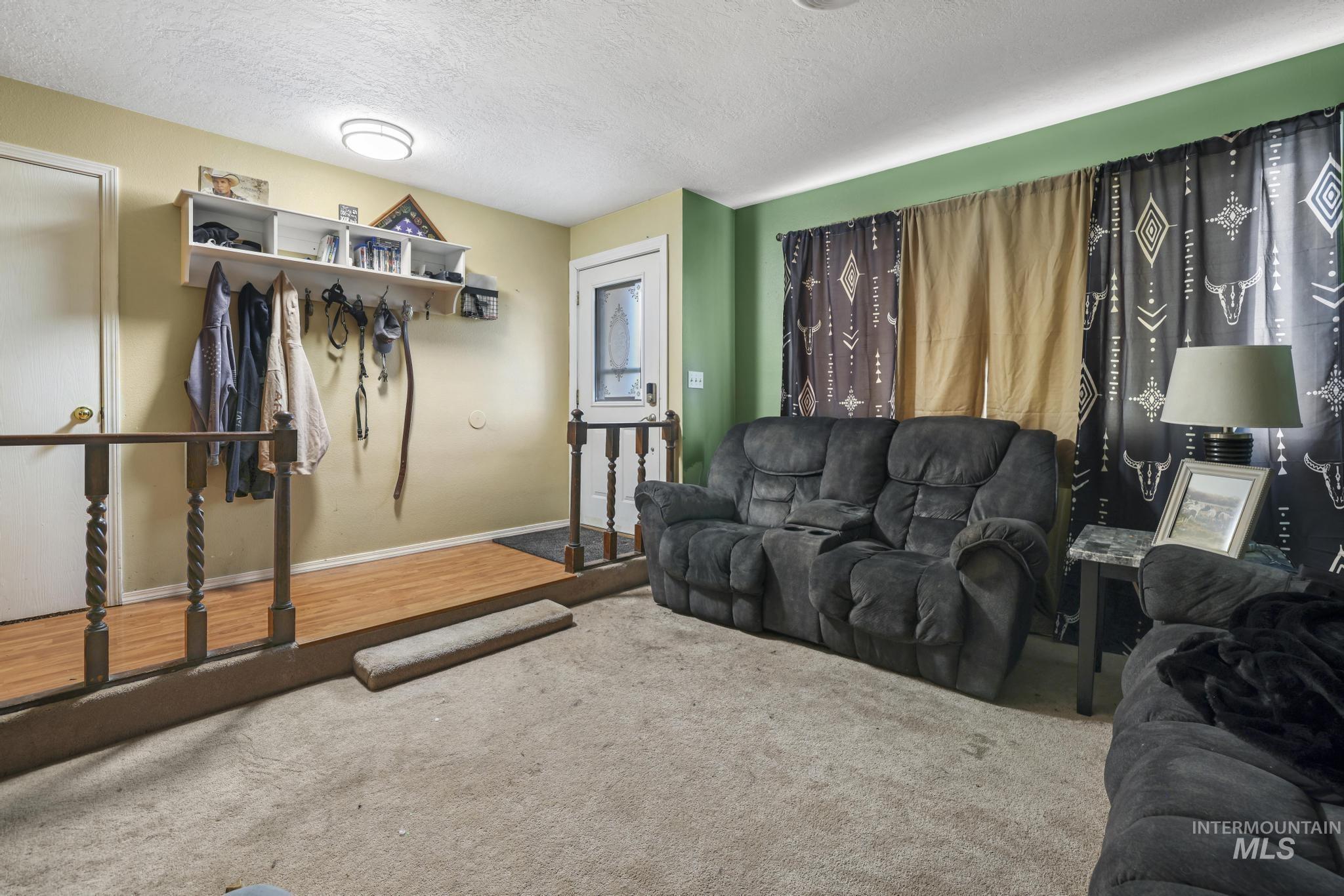 Living area with a textured ceiling and carpet flooring