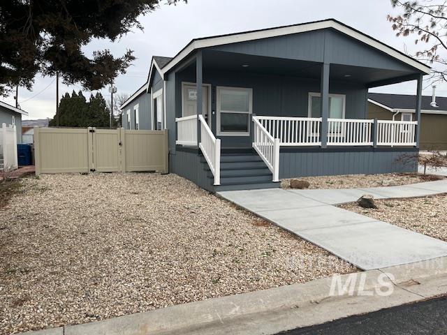 Manufactured / mobile home featuring covered porch and a gate