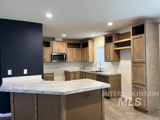 Kitchen featuring a peninsula, light countertops, brown cabinetry, appliances with stainless steel finishes, and recessed lighting