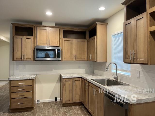 Kitchen featuring open shelves, stainless steel appliances, brown cabinets, light countertops, and recessed lighting