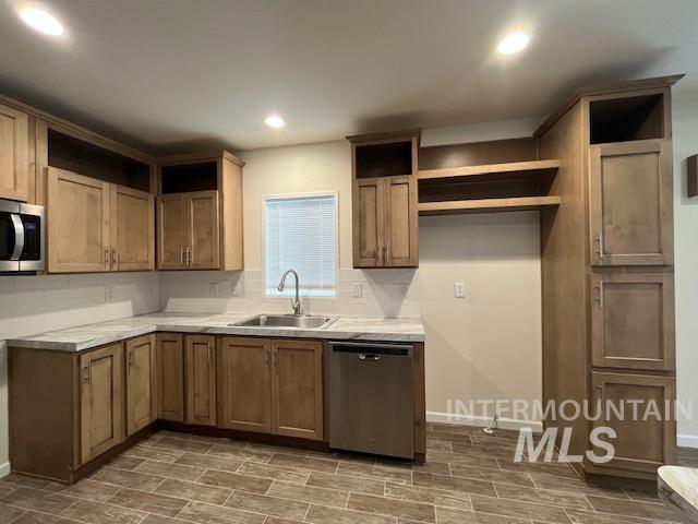 Kitchen featuring open shelves, brown cabinets, appliances with stainless steel finishes, light countertops, and recessed lighting