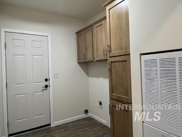 Washroom featuring a heating unit, wood tiled floors, cabinet space, and electric dryer hookup