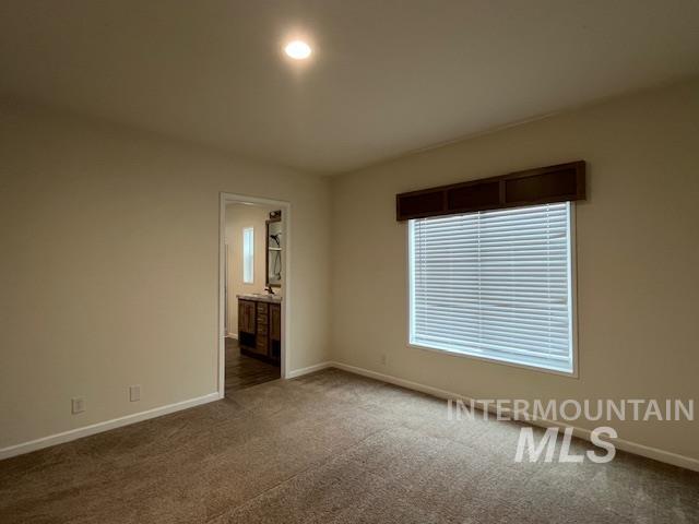 Unfurnished bedroom featuring carpet flooring and ensuite bathroom