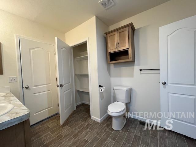 Full bathroom featuring double vanity and wood finish floors