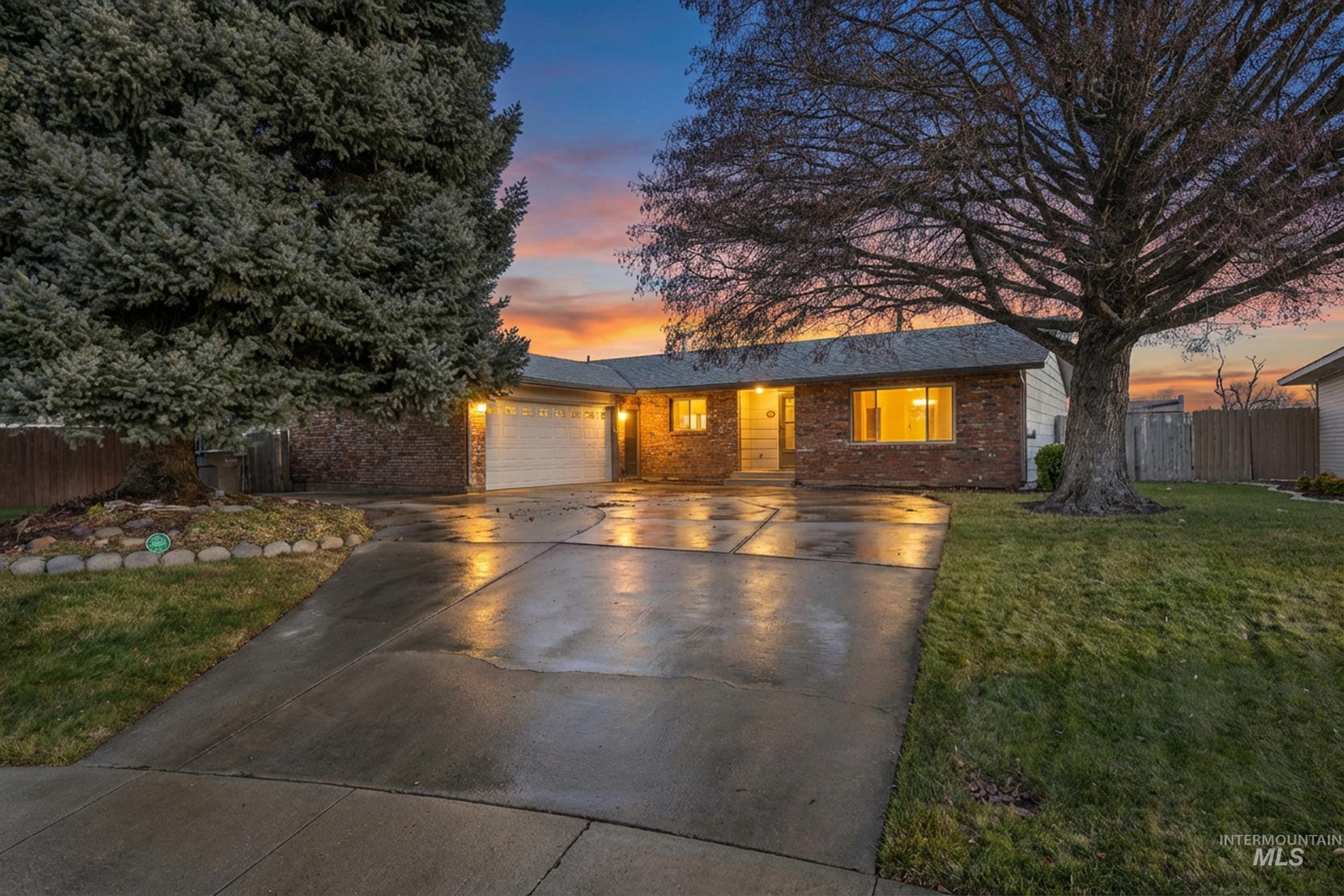 View of front of house with brick siding, driveway, and an attached garage