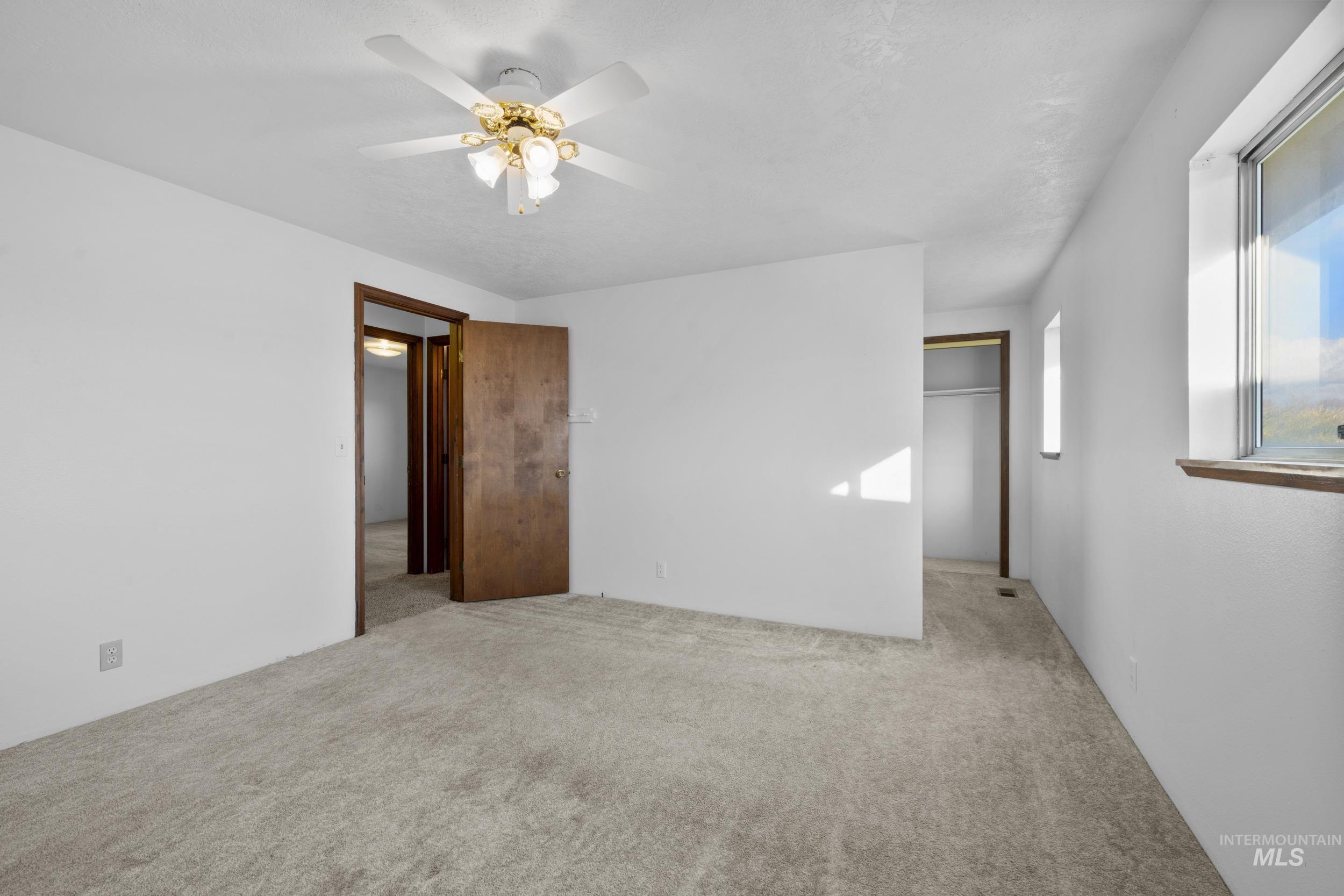 Unfurnished bedroom with carpet flooring and ceiling fan