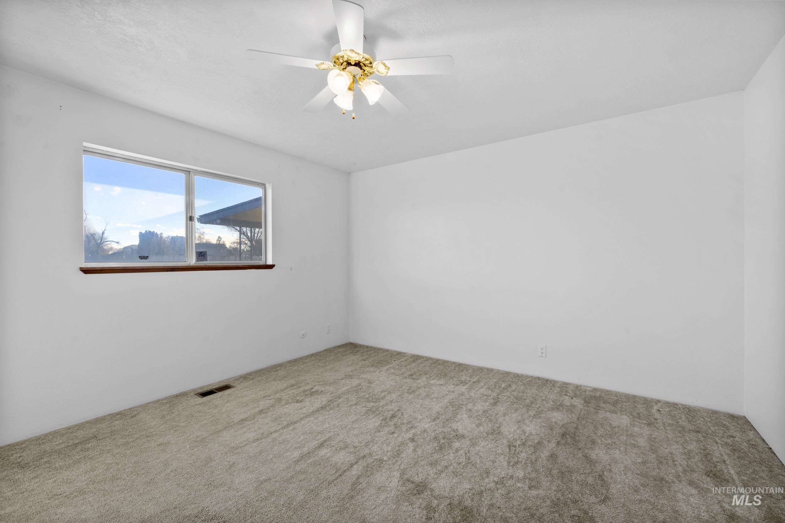 Unfurnished room with a ceiling fan and carpet floors