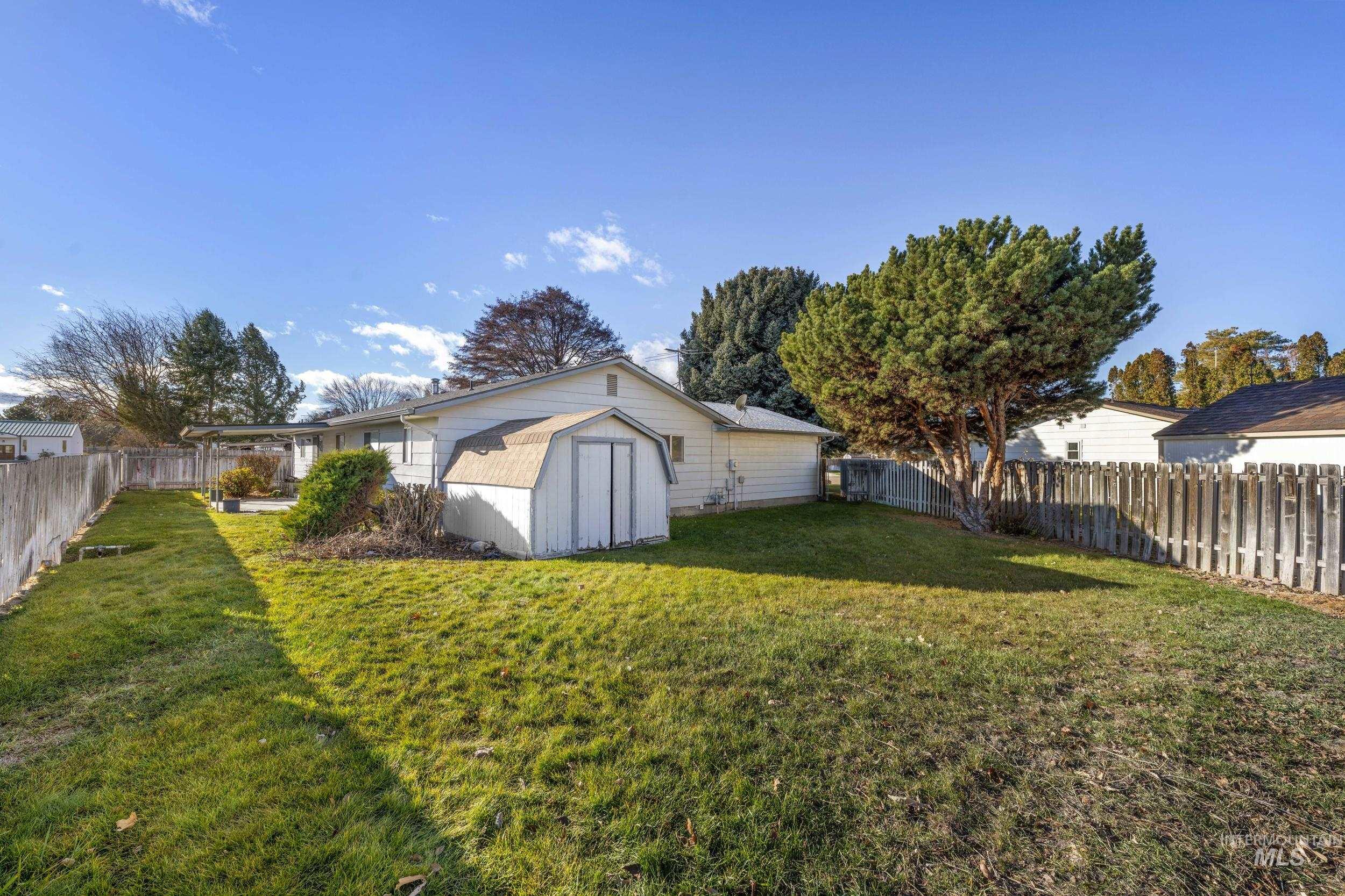Back of house featuring a fenced backyard and a shed