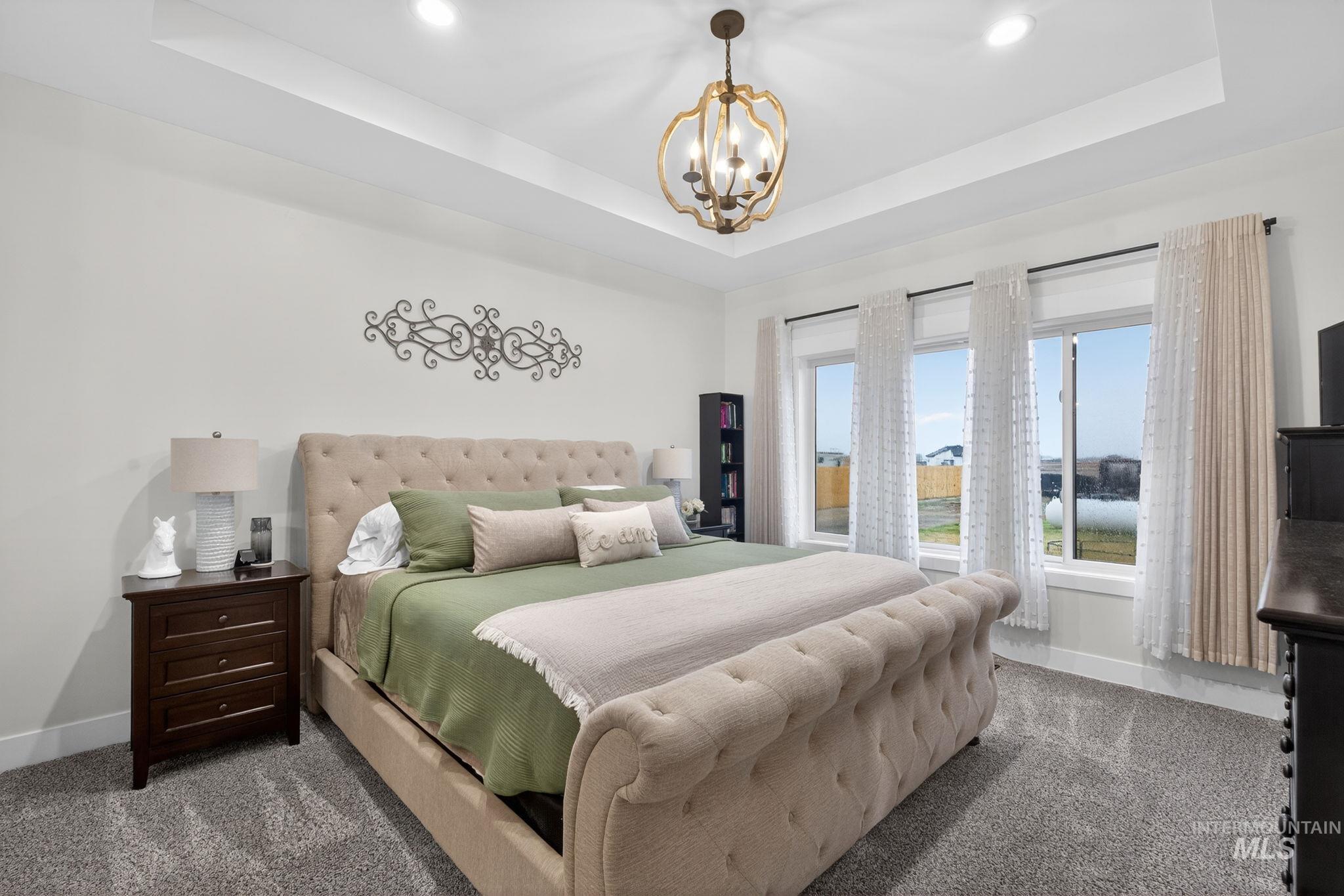 Bedroom with a raised ceiling, recessed lighting, and carpet floors