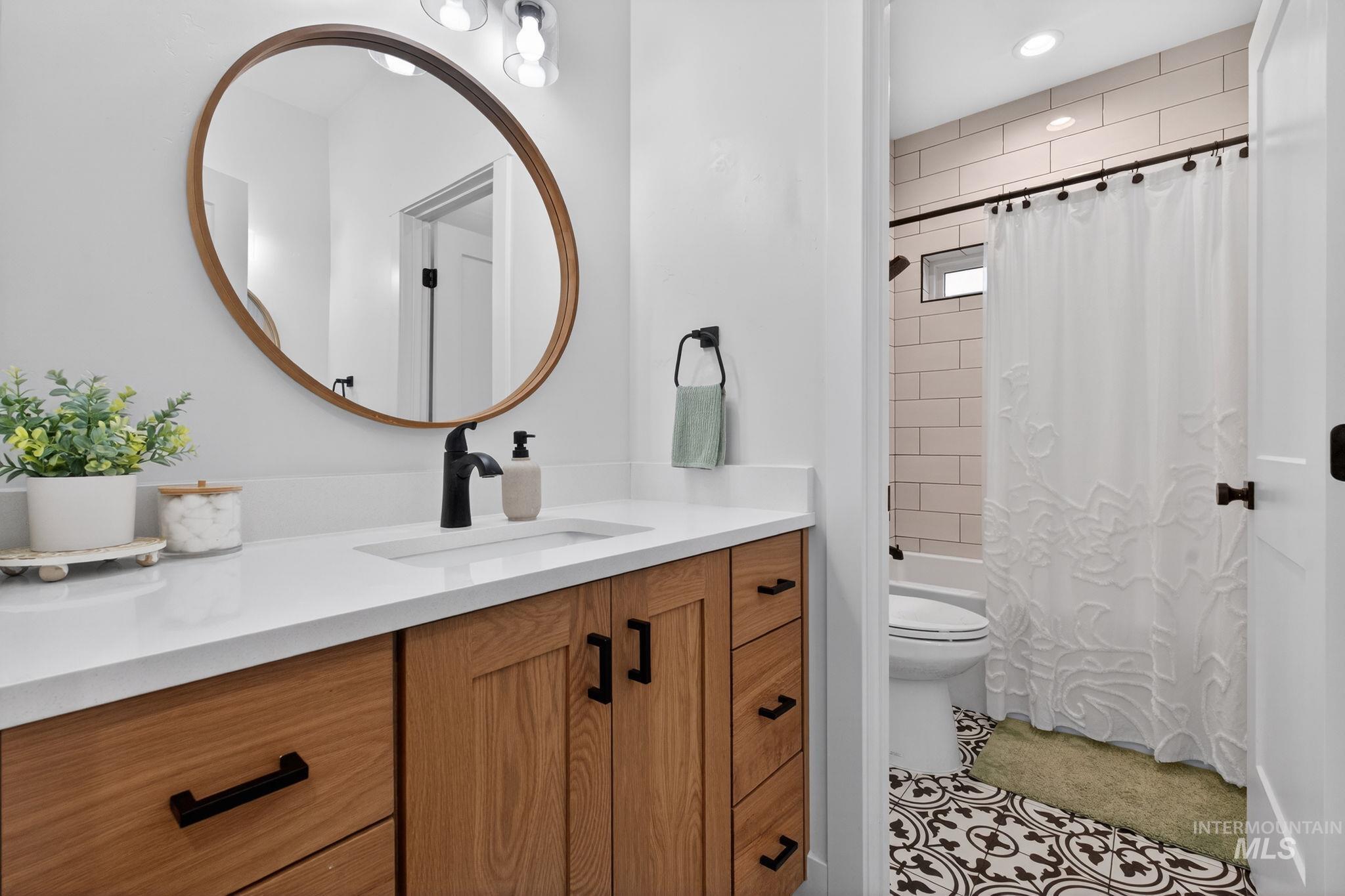 Bathroom featuring vanity and shower / bath combination with curtain