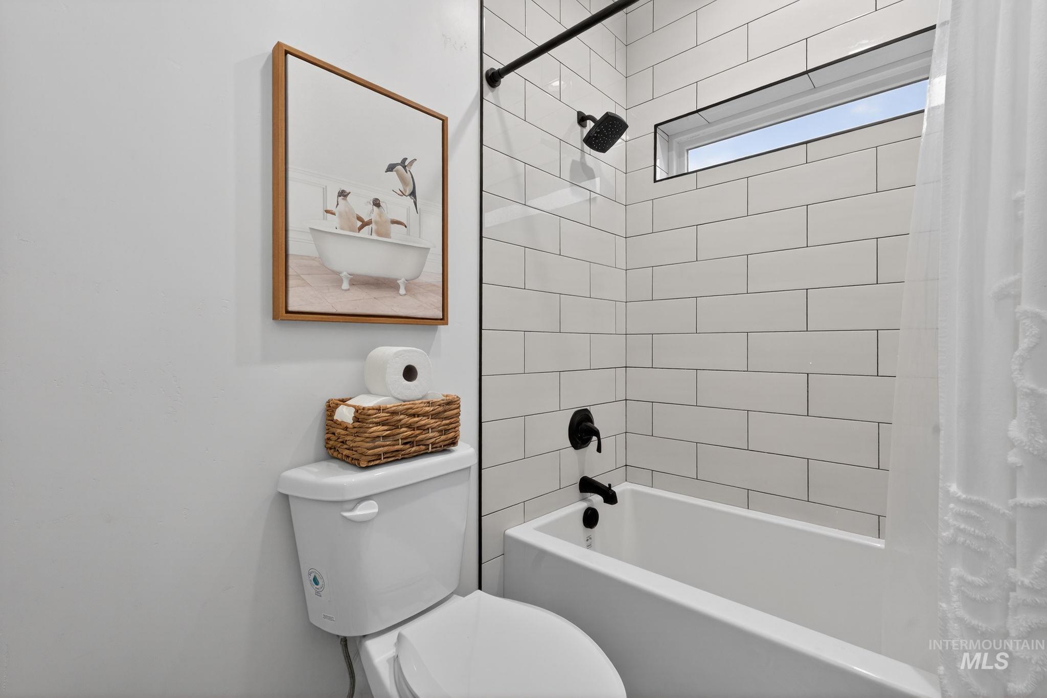 Bathroom featuring shower / bath combination with curtain and toilet