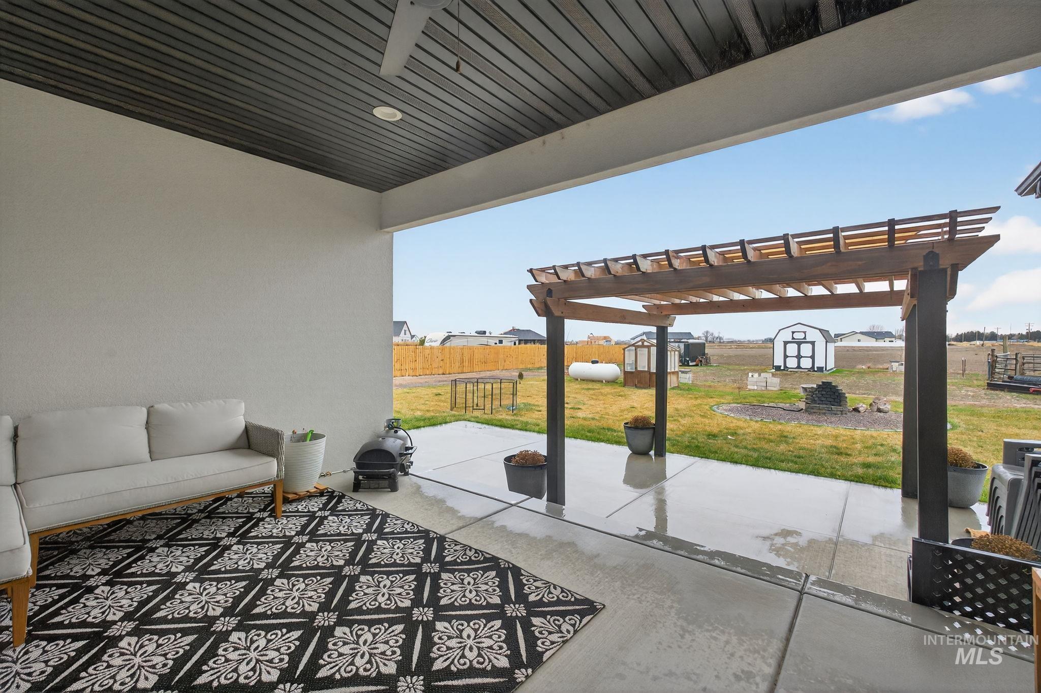 Fenced backyard with a patio area, a shed, a pergola, and outdoor lounge area