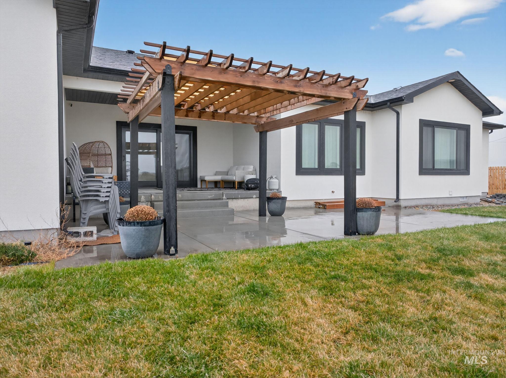Back of house with a patio area, stucco siding, and a lawn