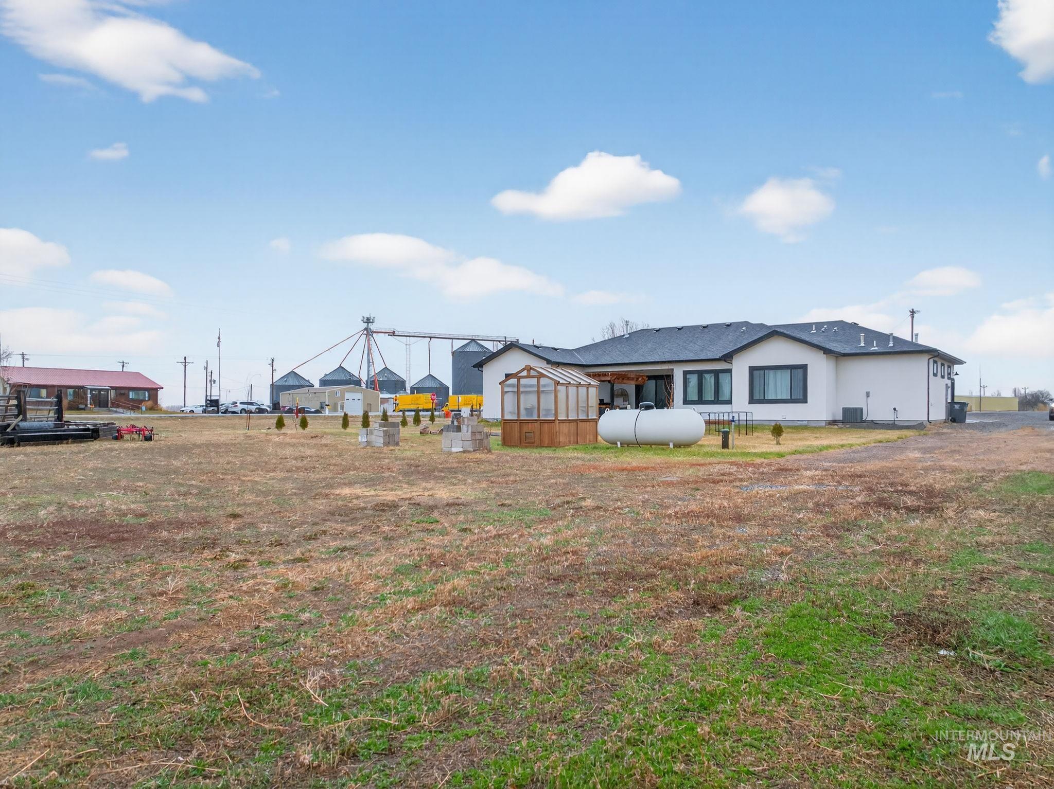 Back of property with a yard and a greenhouse