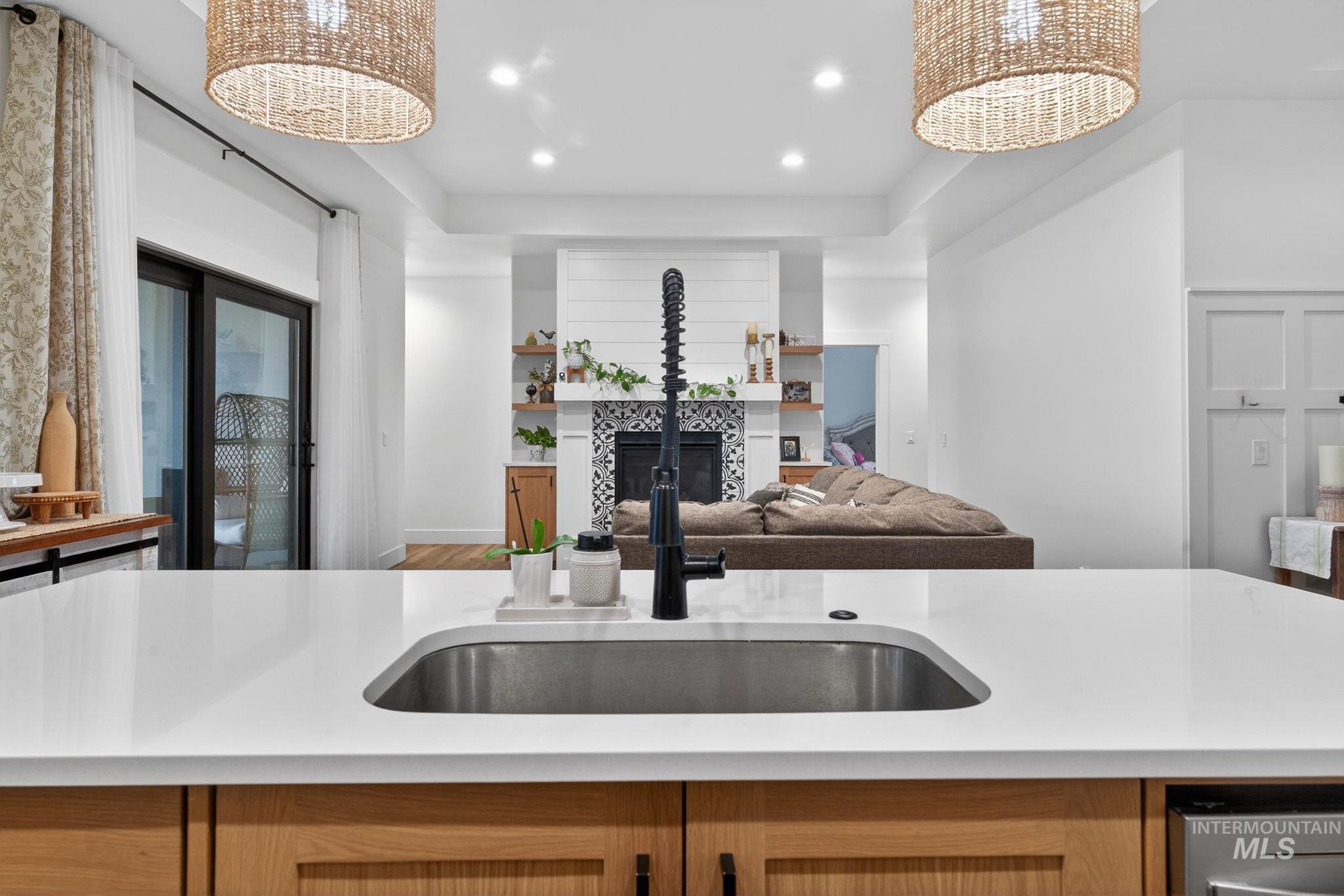 Kitchen with a chandelier, recessed lighting, a fireplace, open floor plan, and light brown cabinets