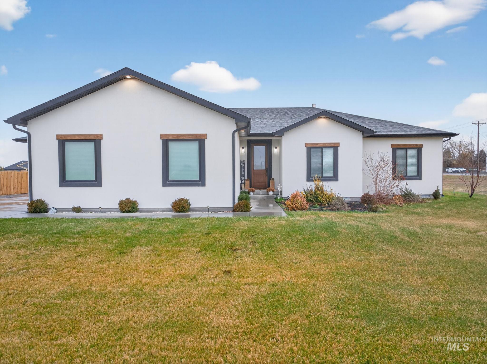 View of front facade with a front lawn and stucco siding