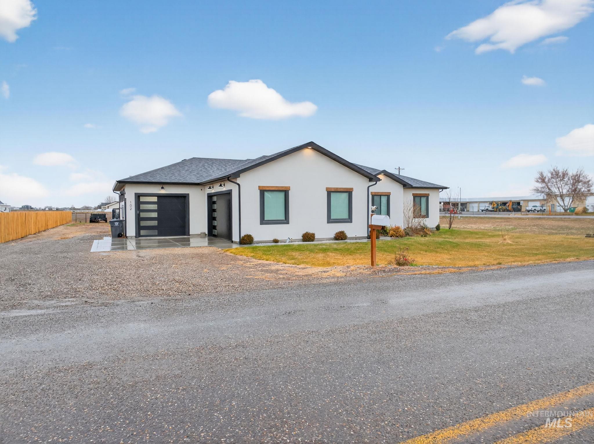 View of front of home with stucco siding, driveway, and an attached garage