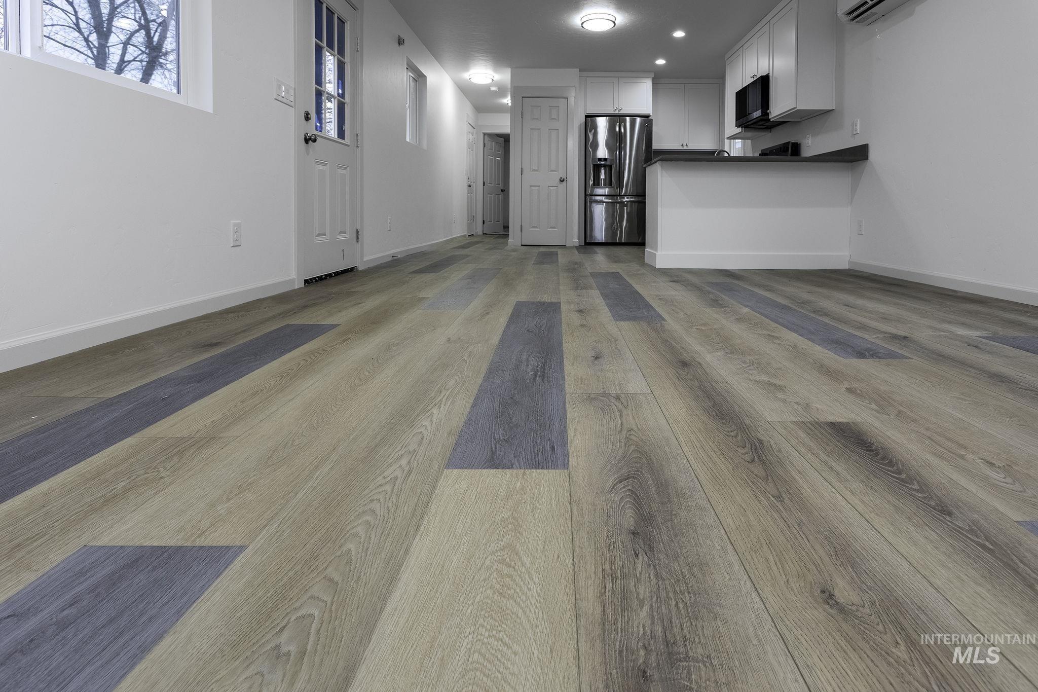 Unfurnished living room with light wood-type flooring, recessed lighting, and a wall mounted AC