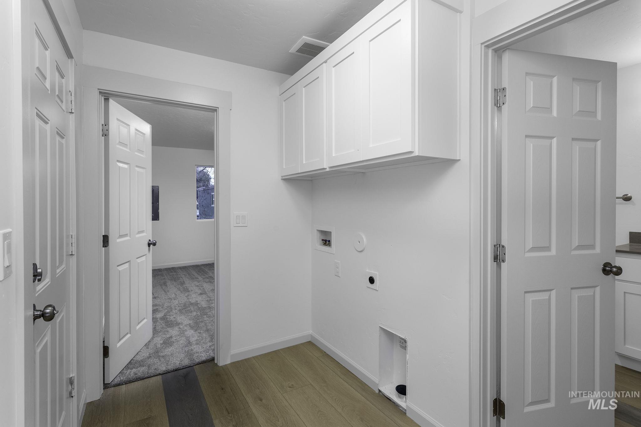 Laundry room with light wood-style flooring, cabinet space, washer hookup, hookup for an electric dryer, and gas dryer hookup