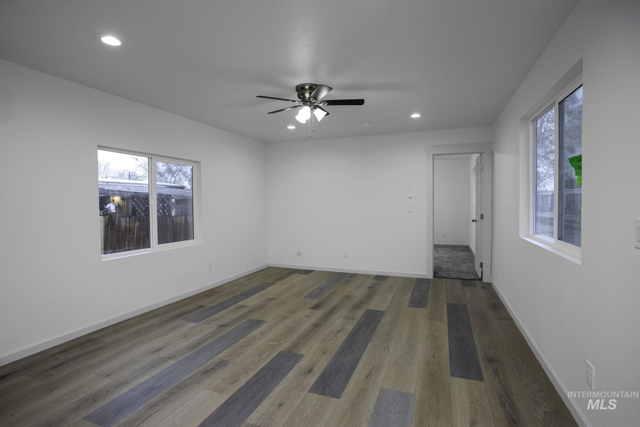 Empty room with recessed lighting, wood finished floors, ceiling fan, and healthy amount of natural light