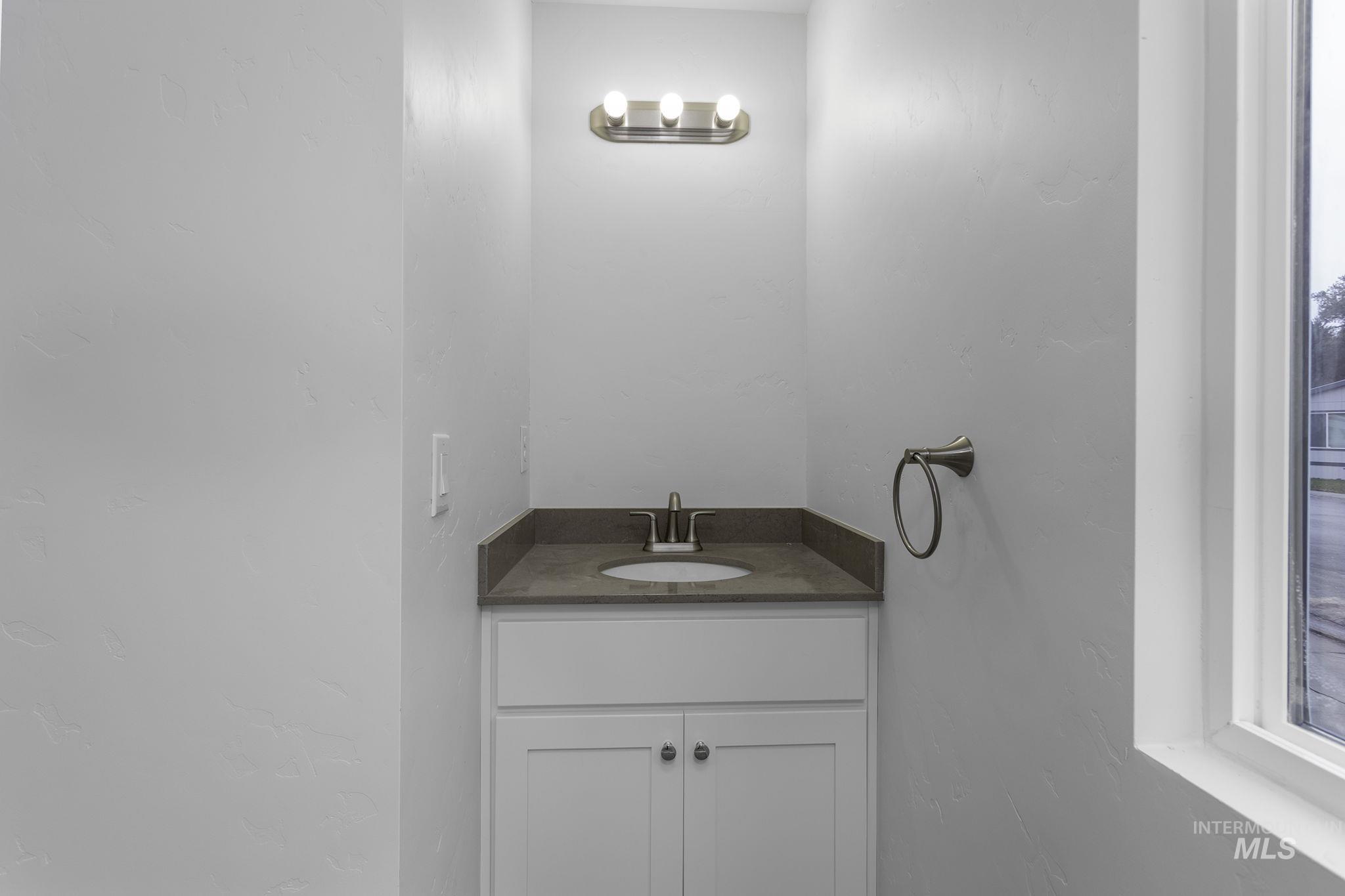 Bathroom with vanity and a textured wall