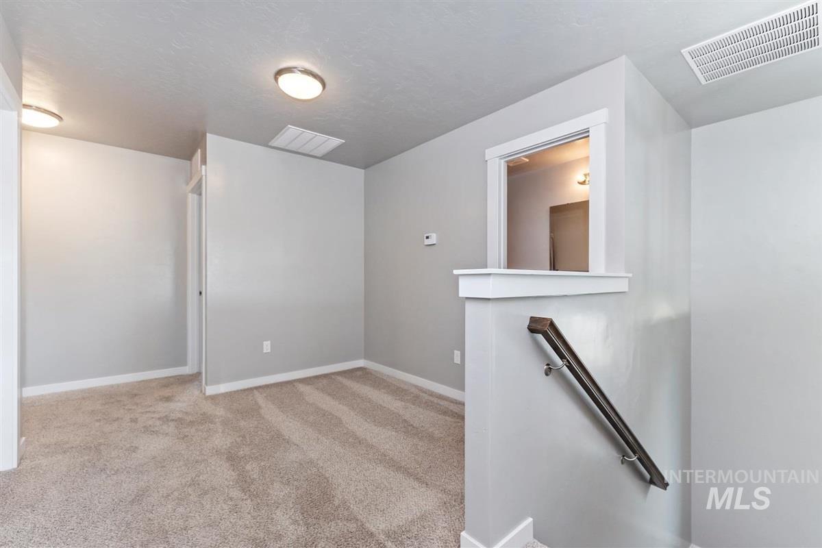 Unfurnished room featuring light colored carpet and baseboards