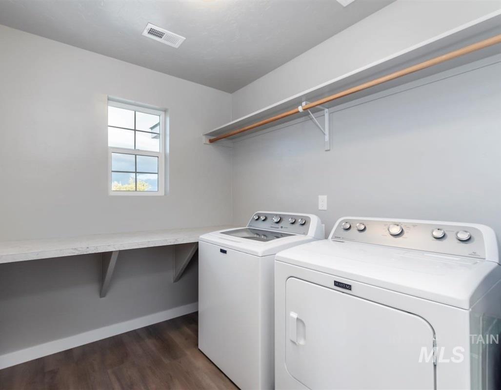 Laundry area featuring dark wood-style flooring and washing machine and dryer