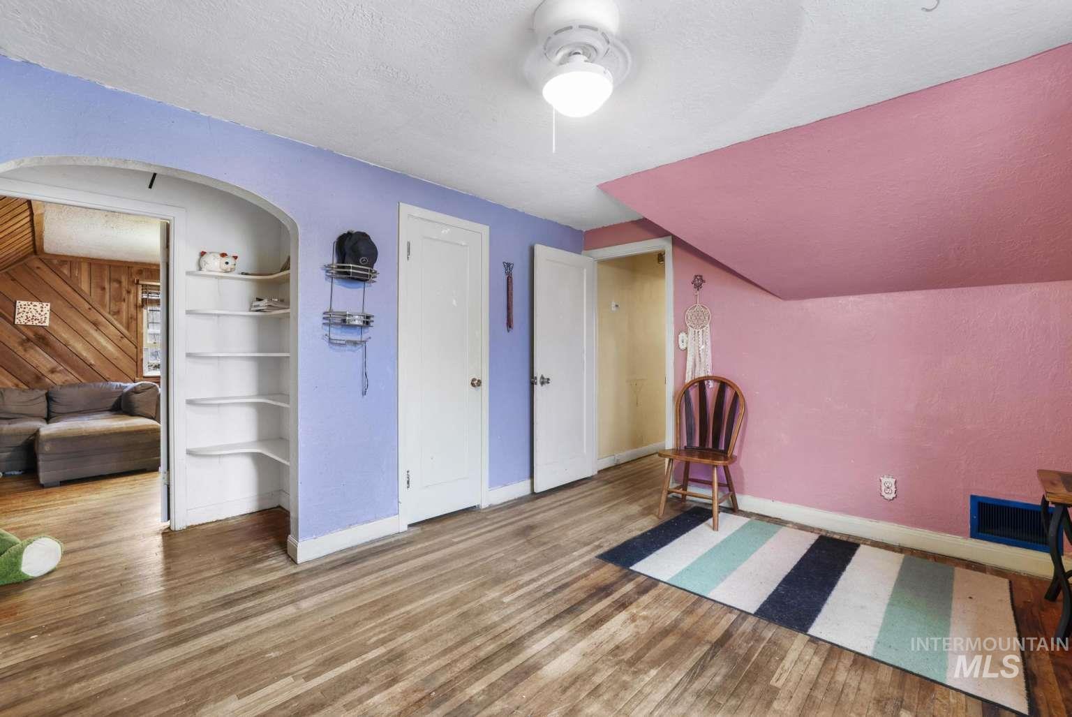 Unfurnished room featuring a textured ceiling, wood finished floors, and built in features