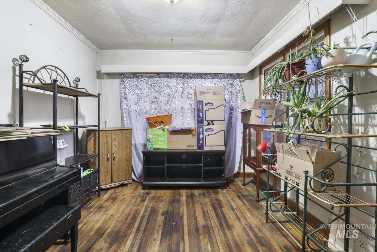Miscellaneous room with dark wood finished floors and ornamental molding