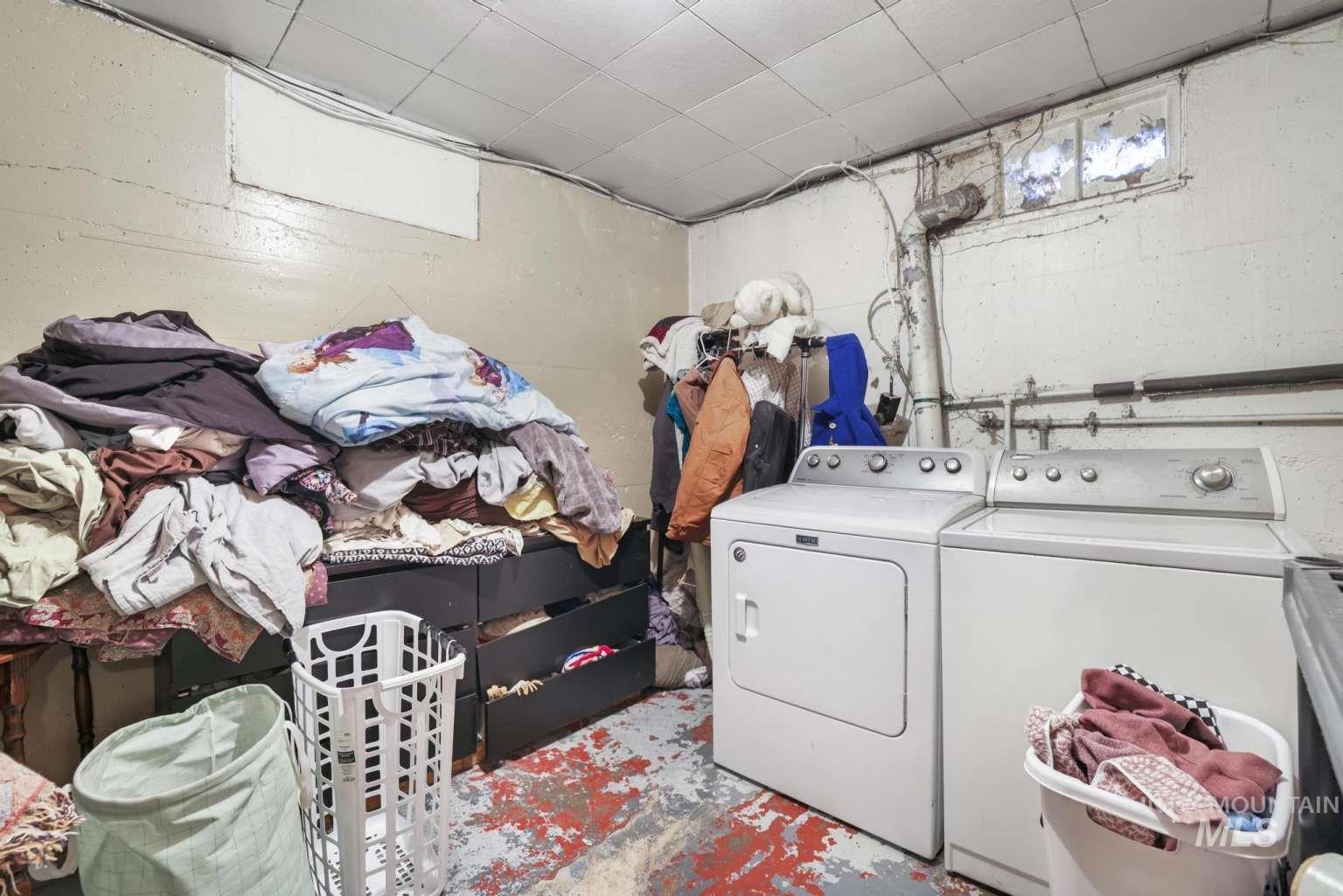 Laundry area featuring separate washer and dryer and unfinished concrete flooring