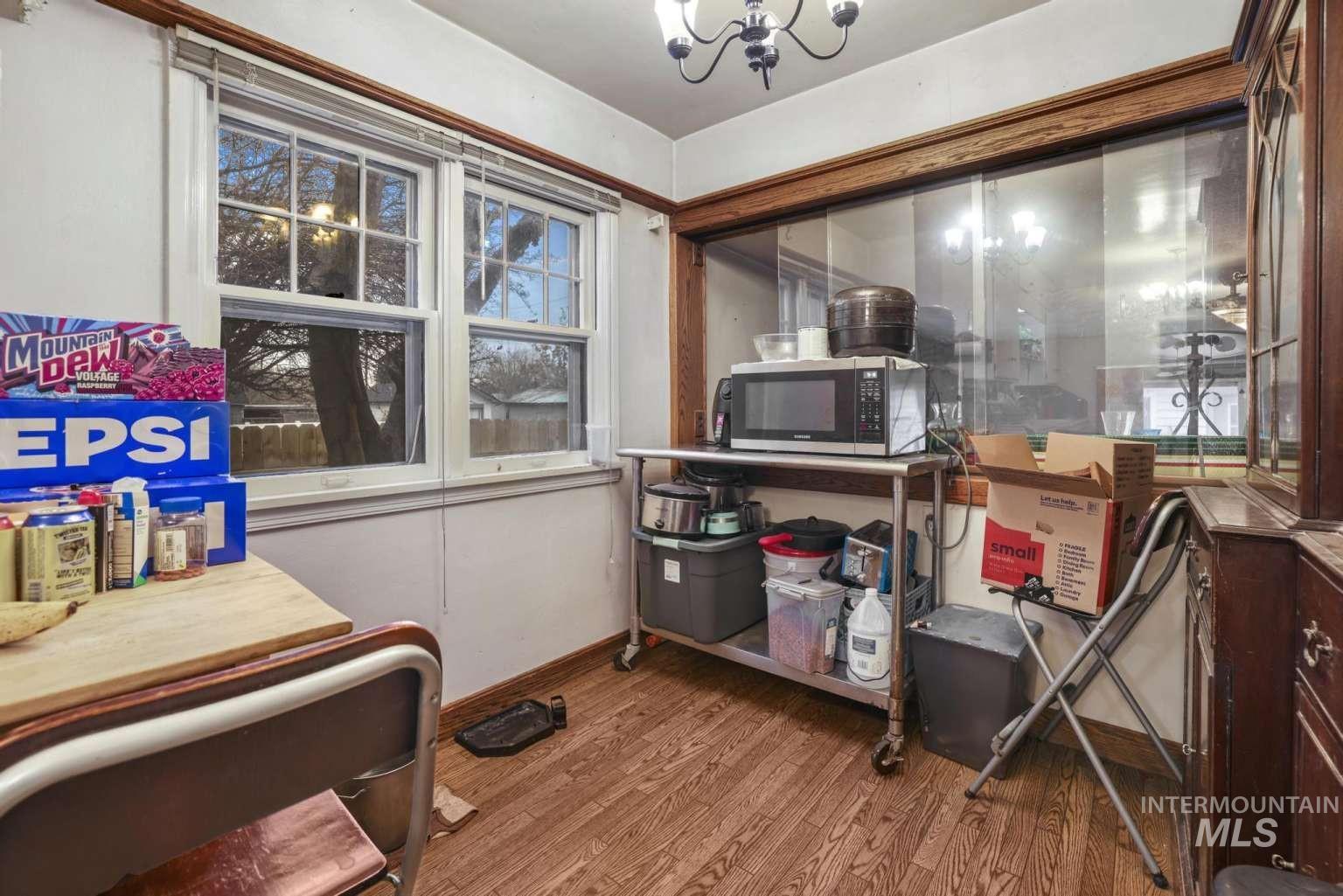 Office with light wood-style floors and a chandelier