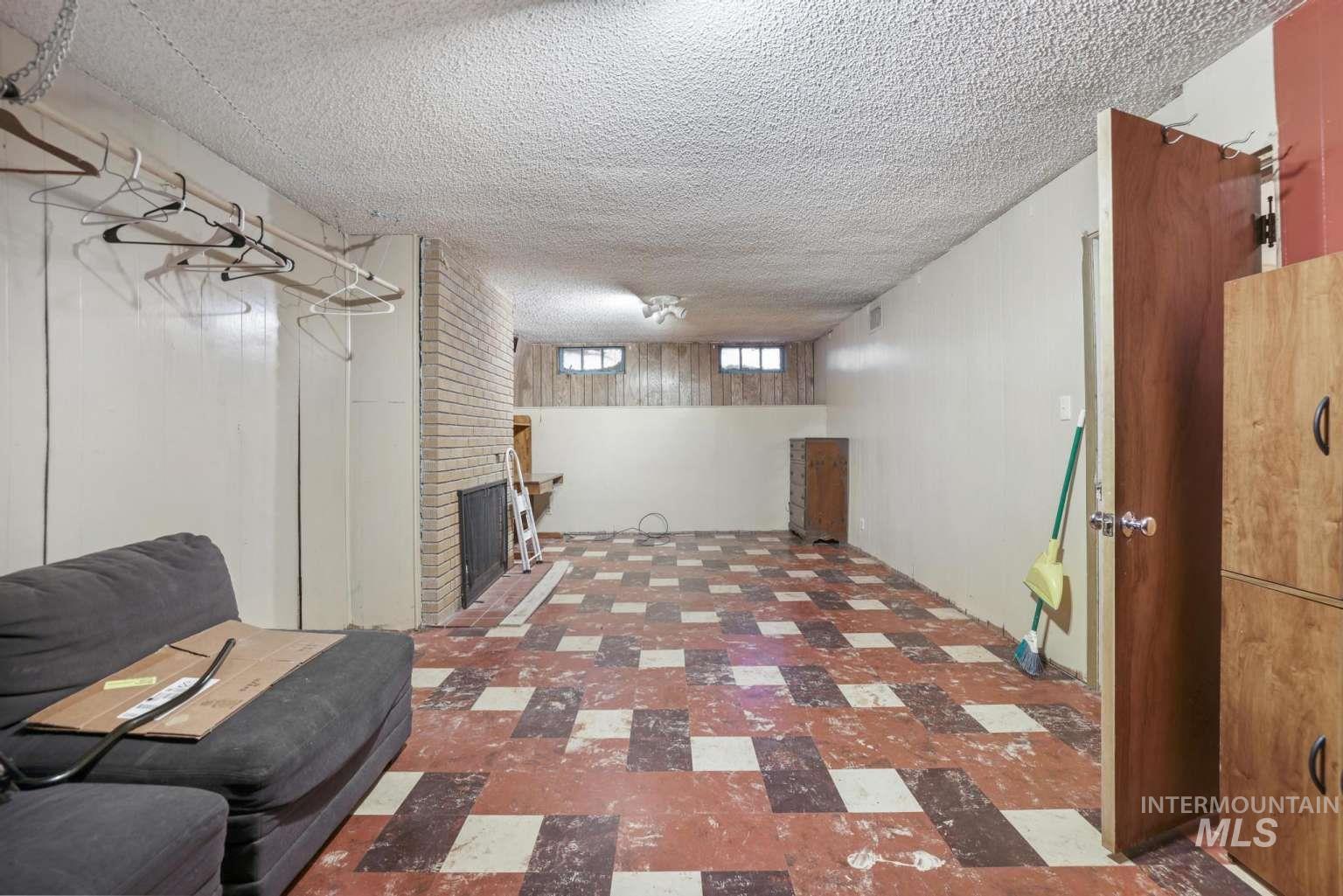Basement featuring tile patterned floors, a fireplace, and a textured ceiling