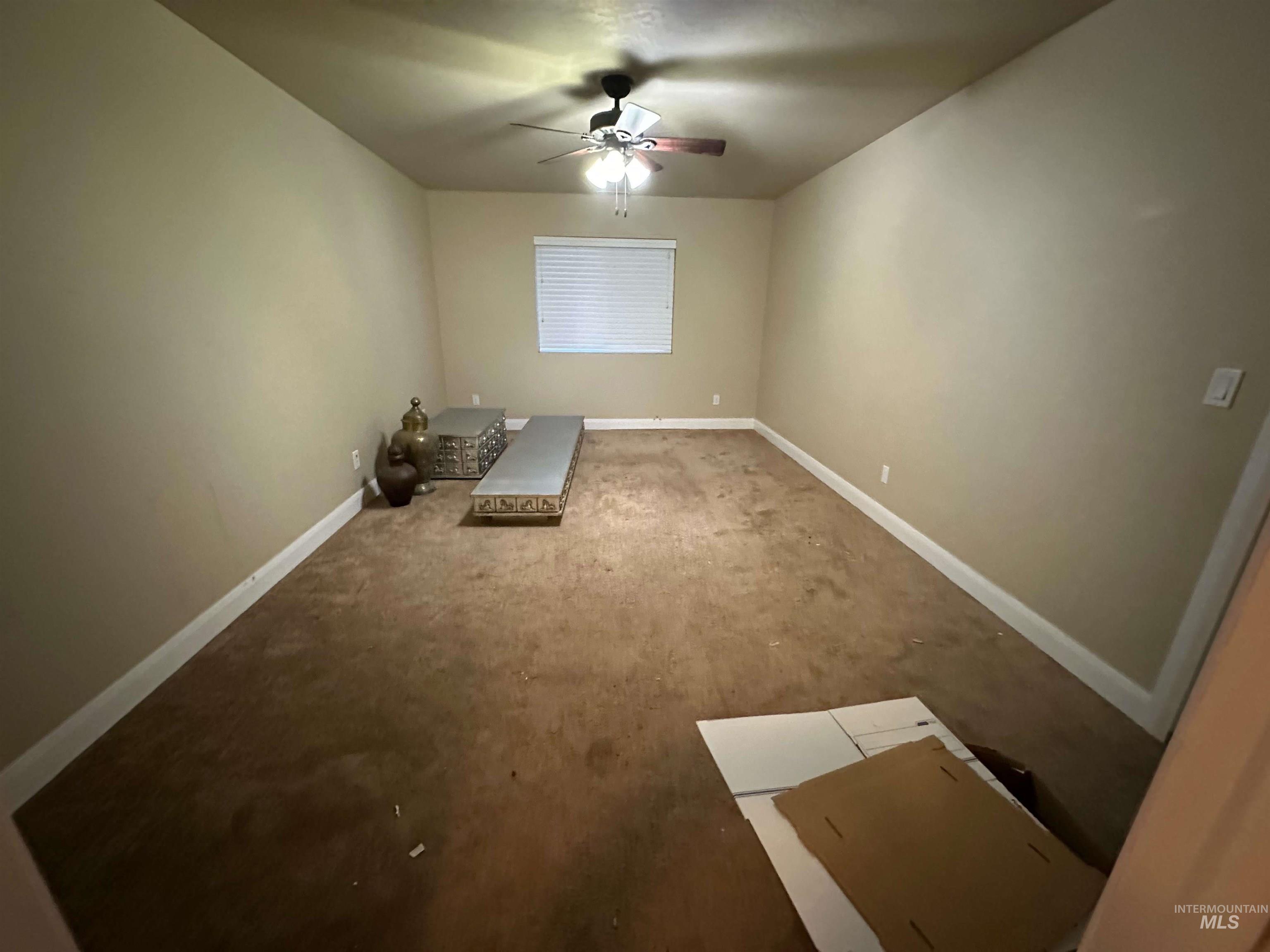 Spare room featuring baseboards and ceiling fan