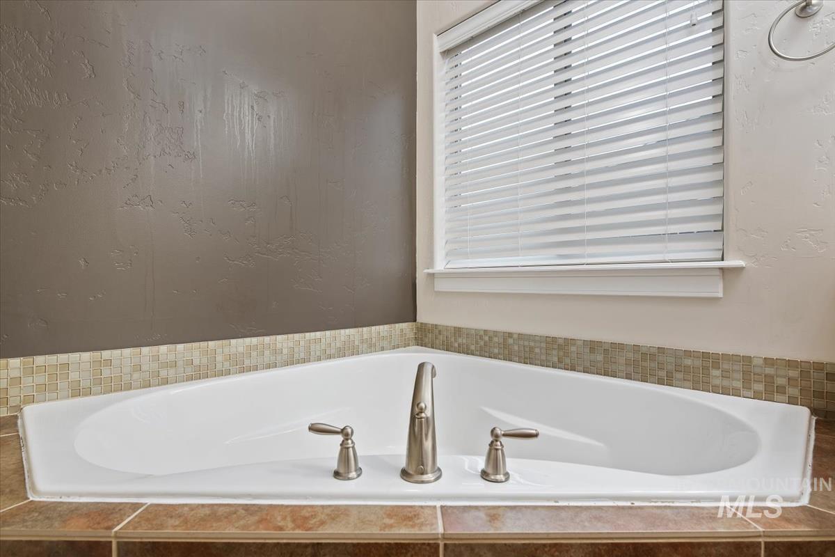 Full bath with a bath and a textured wall