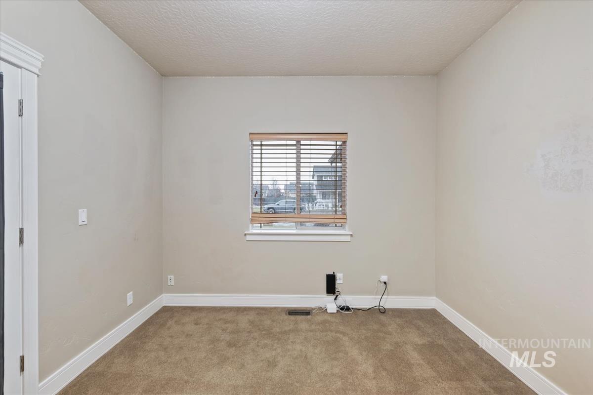 Carpeted empty room with baseboards and a textured ceiling