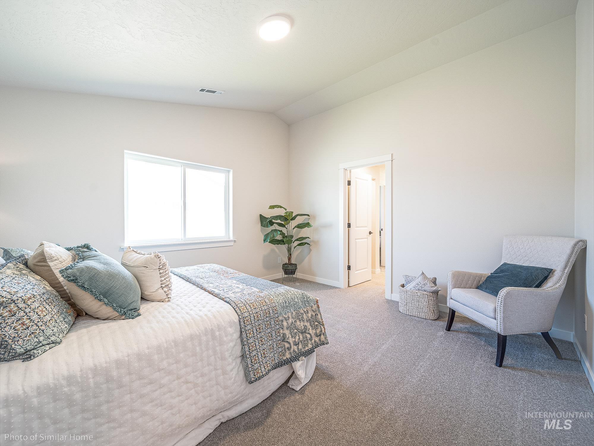 Bedroom featuring vaulted ceiling and carpet floors