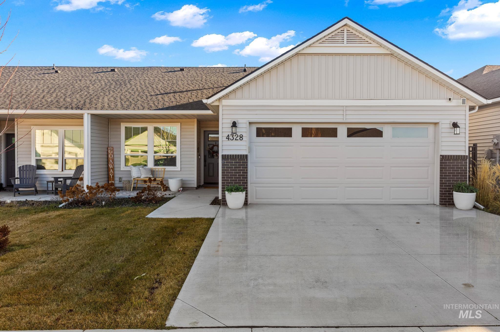 Ranch-style house with brick siding, concrete driveway, roof with shingles, a front yard, and an attached garage