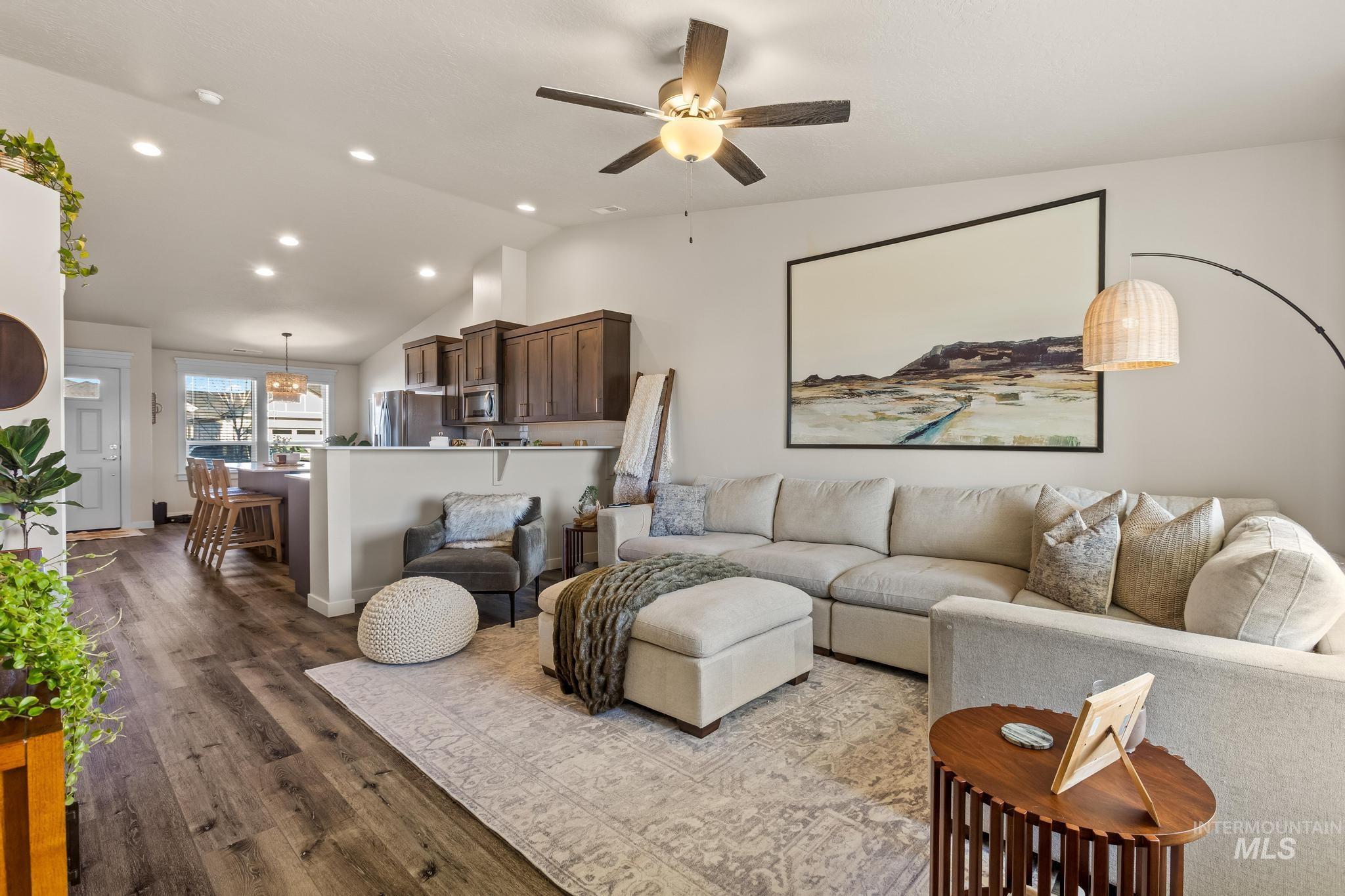 Living room with vaulted ceiling, wood finished floors, recessed lighting, and ceiling fan