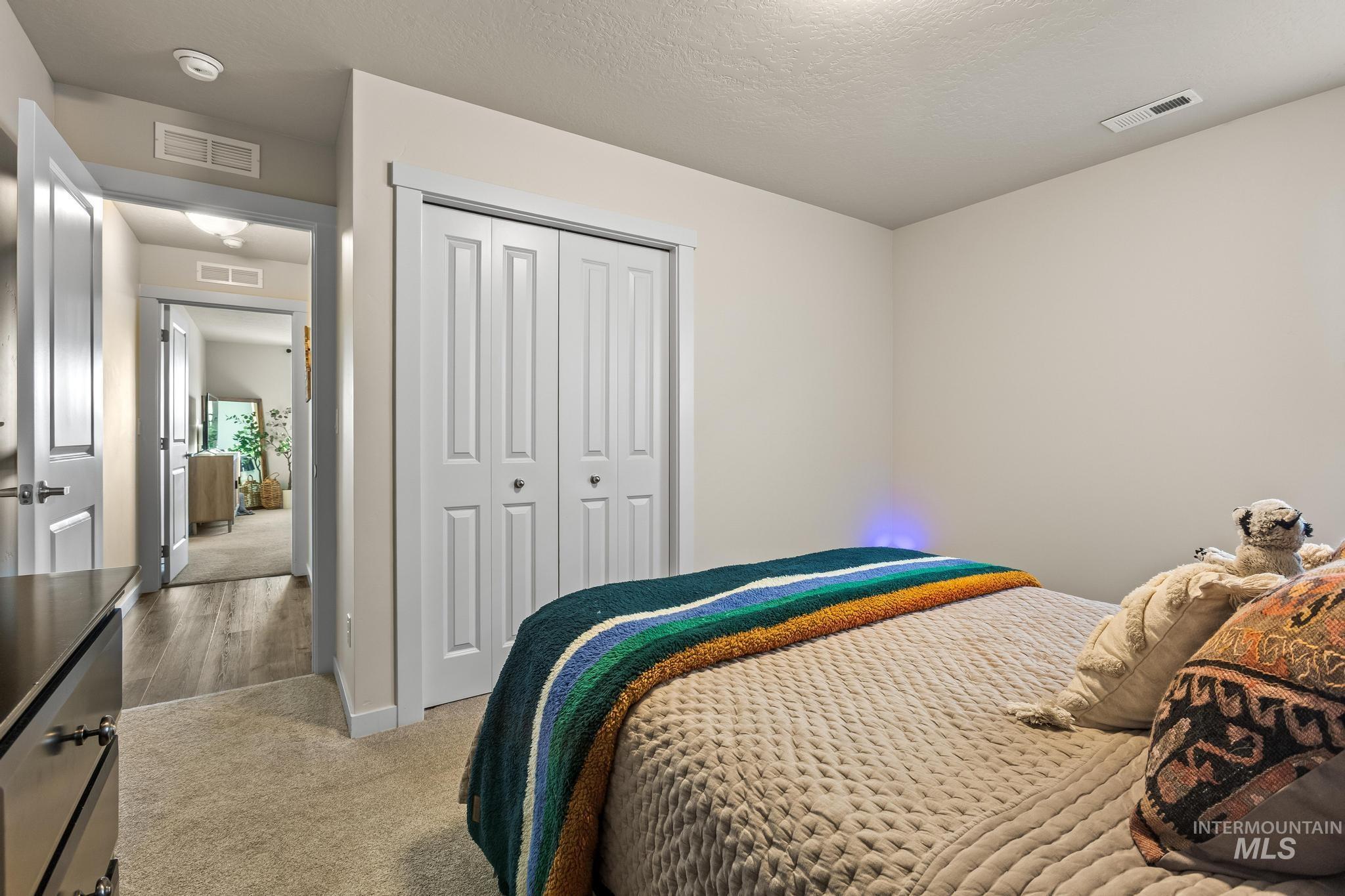 Bedroom featuring carpet, a closet, and a textured ceiling