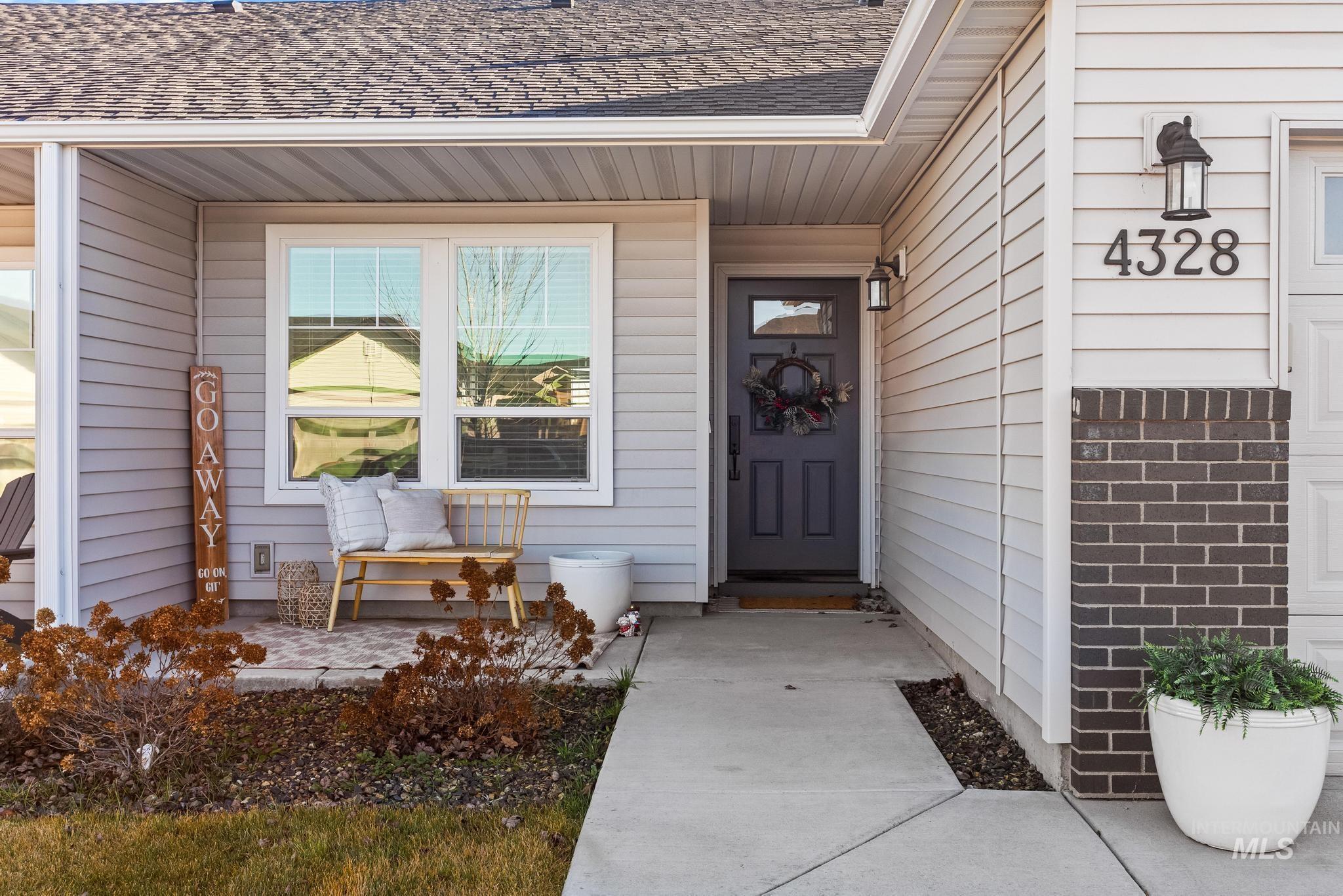 Doorway to property featuring a shingled roof and brick siding