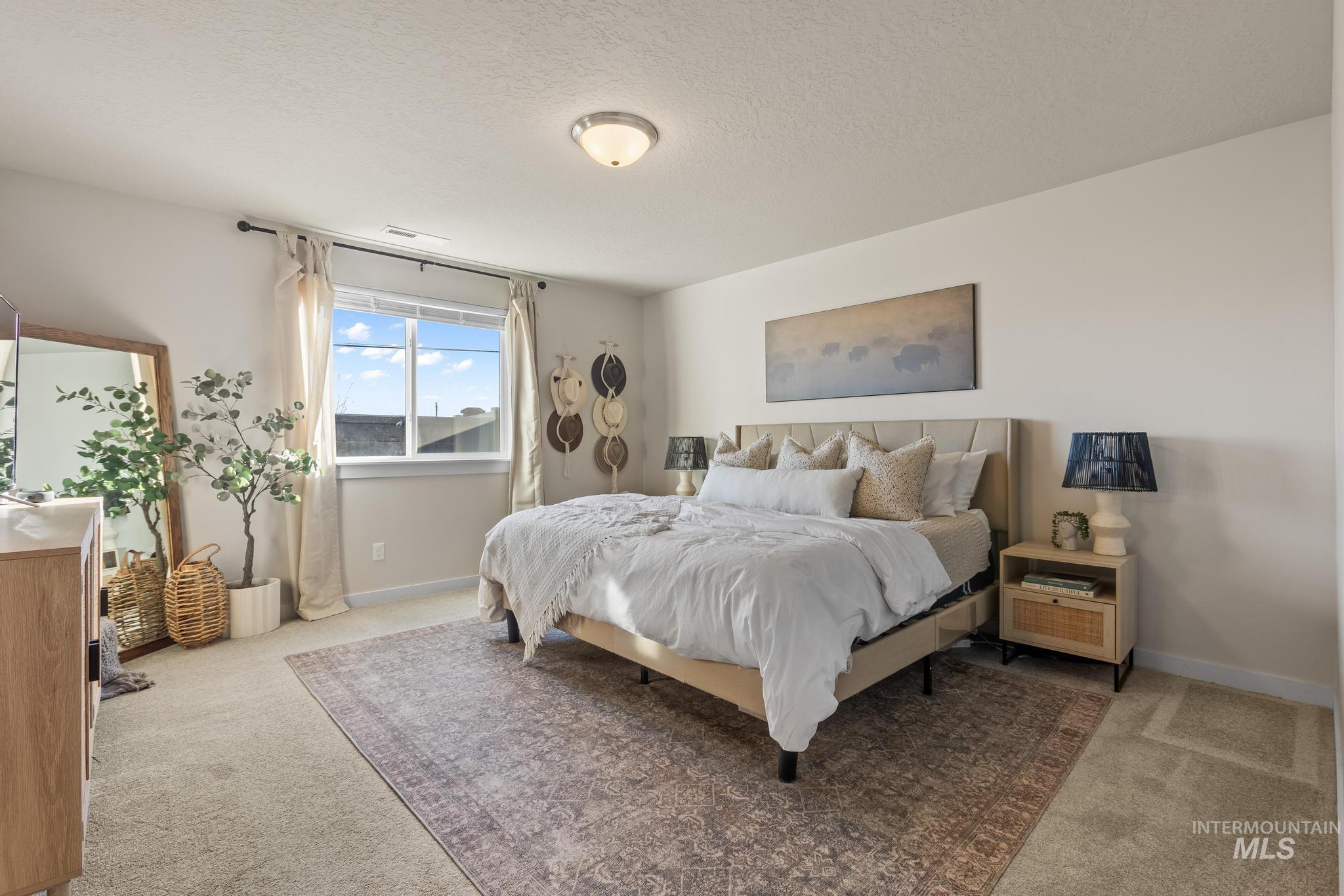 Bedroom featuring light carpet and a textured ceiling