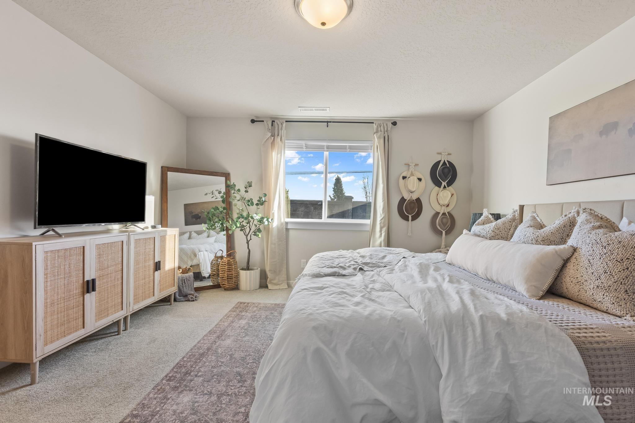 Carpeted bedroom featuring a textured ceiling