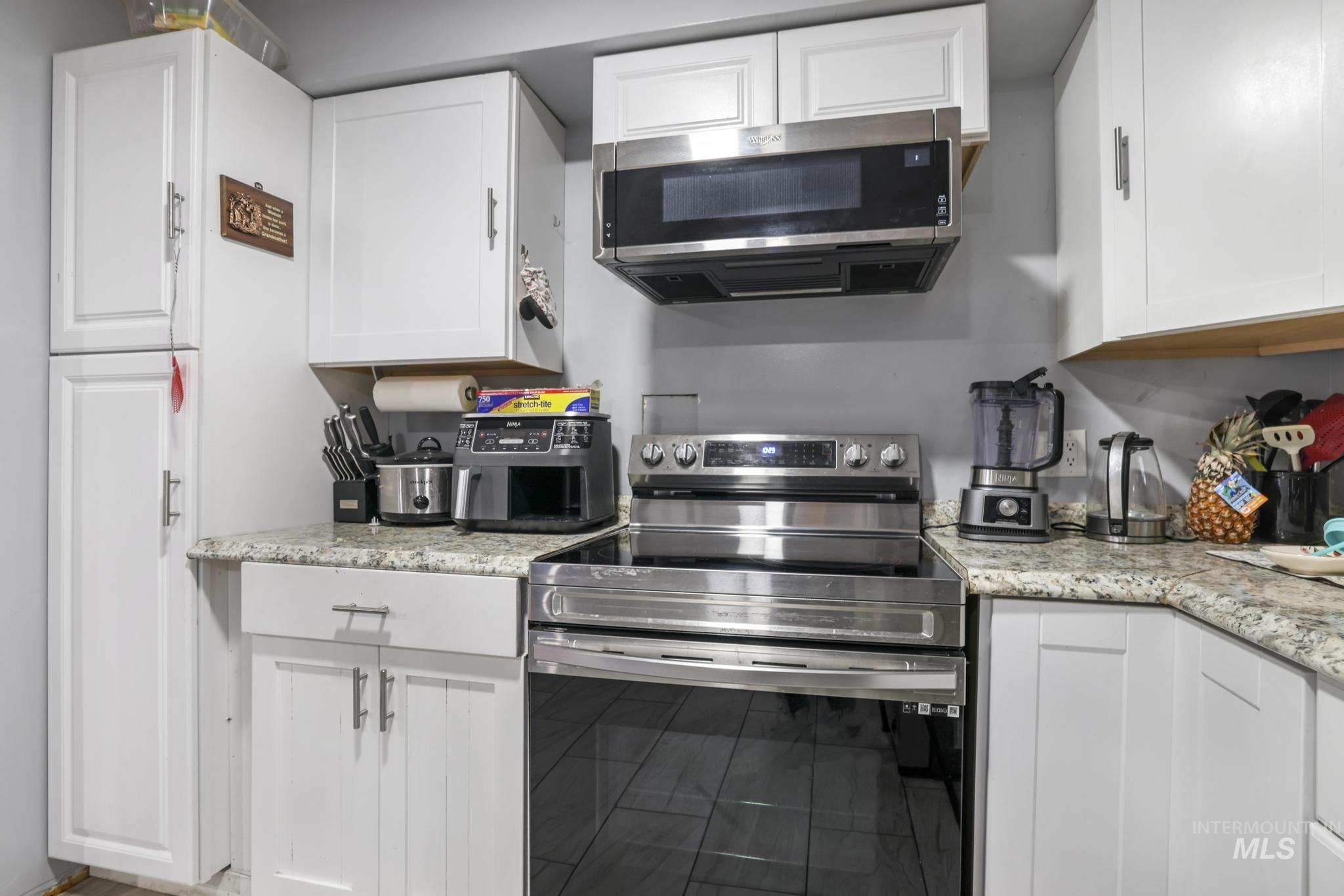 Kitchen featuring appliances with stainless steel finishes and white cabinetry
