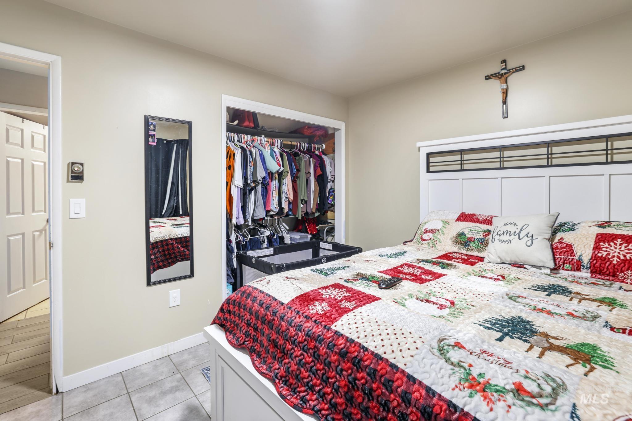 Bedroom with light tile patterned flooring and a closet