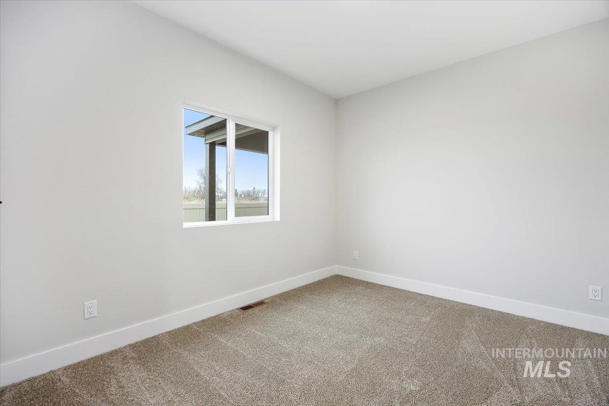 Empty room featuring baseboards and carpet