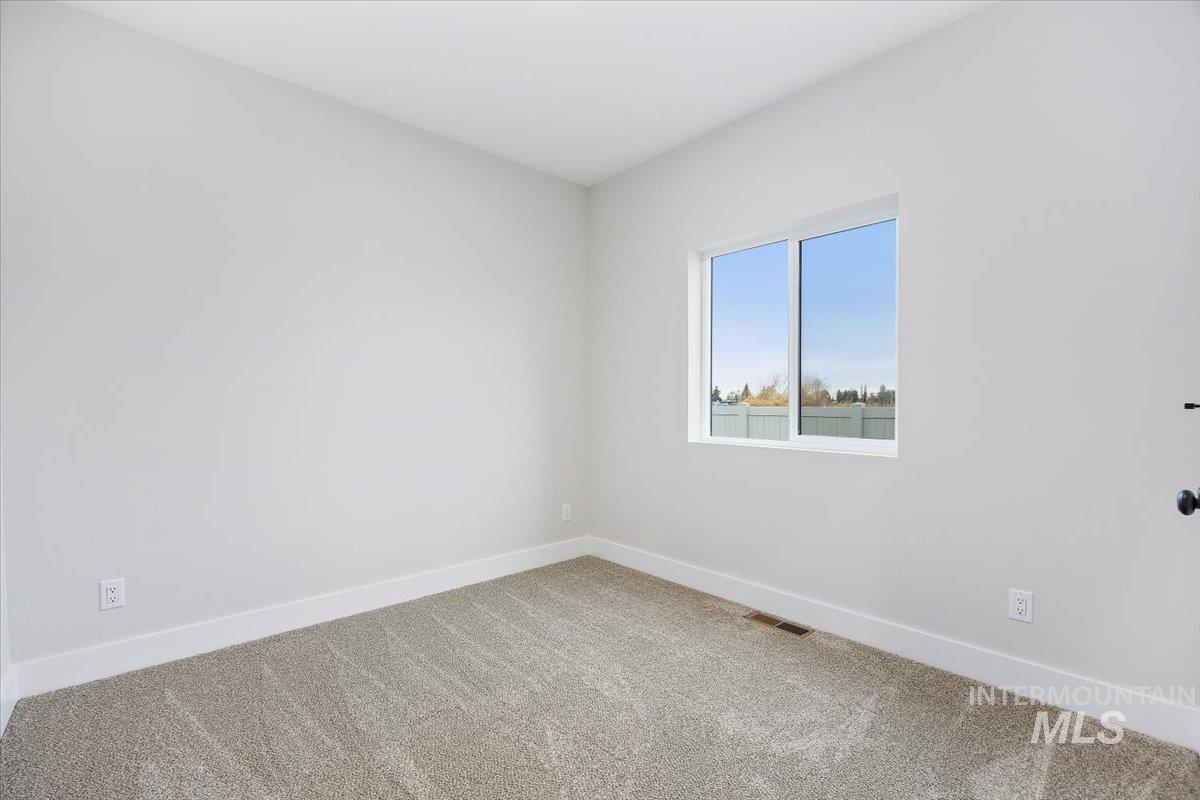 Unfurnished room with baseboards and carpet