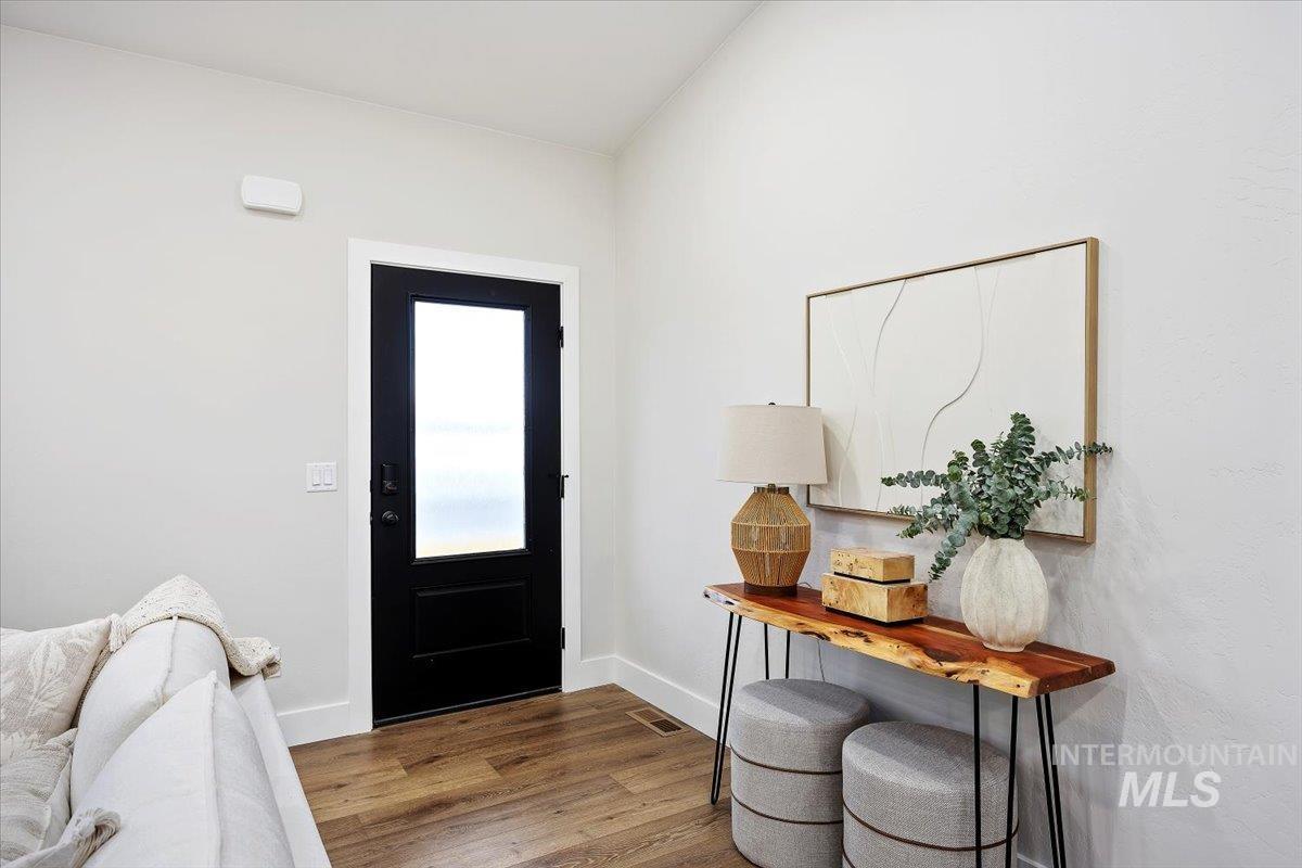 Foyer with dark wood-style floors and baseboards