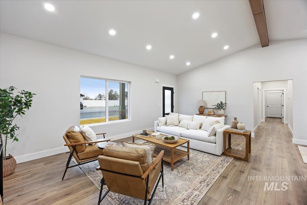 Living area featuring recessed lighting, light wood-style flooring, beam ceiling, and high vaulted ceiling